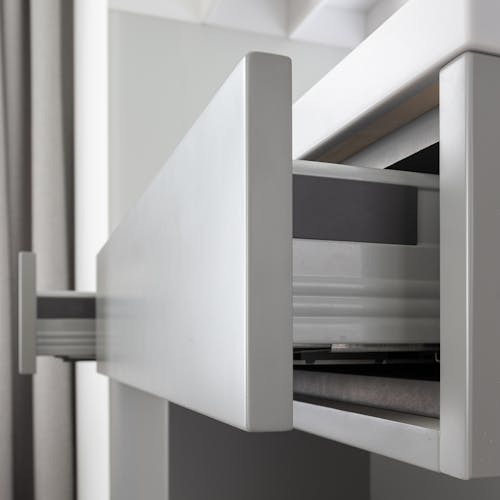 Contemporary expensive cabinet with clean white drawers in modern residential apartment in daytime